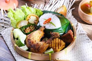 Nasi Ayam Bakar, roasted chicken with tempeh, chilli paste and vegetable. Indonesian food photo
