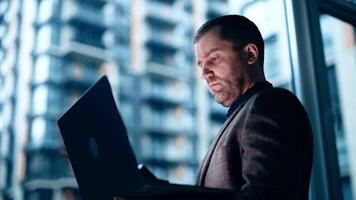 Portrait of Busy, confident Male Using Laptop Computer to Analyze How to Proceed with the Artificial Intelligence Software. Casually Chatting in High Tech Research Office video