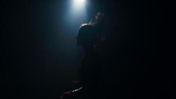 Woman fighter doing exercises with jump rope in dark room under lights. Boxer training in a smoky studio in slow motion. Silhouette against a dark background. video