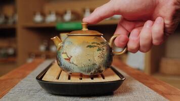 A person pours tea into a teapot on a wooden table, creating tranquility. Media video