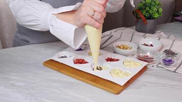 Filling out forms with various colorful ingredients from confectionery bag, liquid white chocolate video