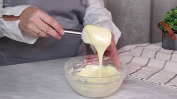 Mixing molten cream made of white chocolate in a glass bowl video