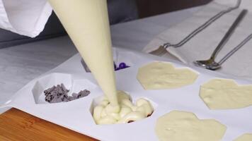 Filling out forms in the form of a heart with various colorful ingredients from a confectionery bag, liquid white chocolate video
