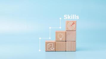 Upskilling, reskilling, new skills icon on wooden cube, Goal is constant skill growth, Improvement of personal skills in business, life and career, Upskilling and personal development concept. photo