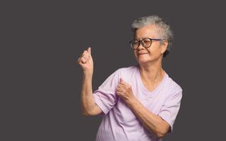 Senior woman showing hands up and looking away with a smile photo