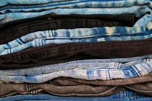 A stack of jeans on the shelf in the store. Close up photo