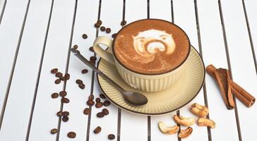 Cup of nut cappuccino on wooden white table side view photo