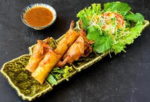Traditional fried vietnamese spring rolls with pork, shrimp, rice paper on black background side view photo