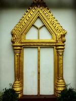 Gold framed archway with a window in the middle. The archway is ornate and has a triangular shape photo