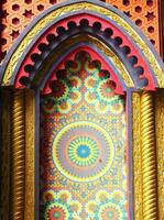 Traditional building of an asia ethnic pattern design background. Colorful design with a yellow circle in the center. The circle is surrounded by a pattern of flowers and leaves photo