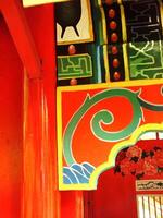 Traditional Classic and Ethnic wooden wall with red and green spiral design. The wall is painted in a bright color and has a lot of detail photo