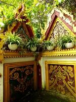 Old traditional ethnic building with two arched shape, and completed with a plant pot. The building are decorated with gold and red designs, giving the building a unique and ornate appearance photo