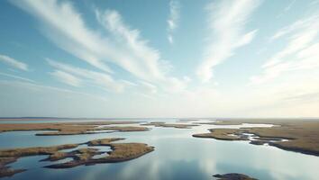 Wide open landscapes with calm waters and scattered clouds in the sky photo