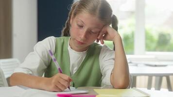 Sad upset bored teen school girl Caucasian kid child pupil daughter student at desk tired lazy schoolgirl studying lesson reading boring learning in classroom problem study write task think education video