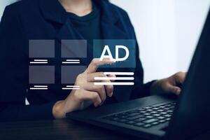 Businesswoman selects advertisement displayed on notebook computer screen on internet. Online advertising. Digital marketing concept. photo