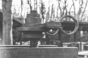 Metal equipment on a workshop table with a blurred forest backdrop and sunlight filtering through the trees in the early morning photo
