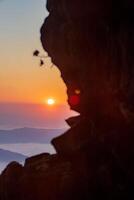 The cliff shows the fog as the sun rises over the golden sky in the background. Thailand. Rainforest. Bird's eye view. Aerial view. photo