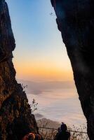 The cliff shows the fog as the sun rises over the golden sky in the background. Forest Park, Thailand. Rainforest. Bird's eye view. photo