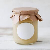 Glass Jar with Yellow Preserve Rustic glass jar with yellow preserve on simple white surface For Social Media Post Size photo