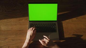 Top view woman hand scroll on a laptop computer touchpad with green screen chroma key video