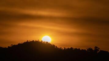 Sun breaks through clouds to bathe a mountain ridge in golden light. video