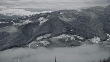 Slow optical zoom out from a misty snowy mountains view video