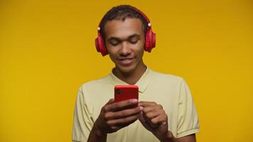 Man celebrating with a fist pump using smartphone on yellow background video