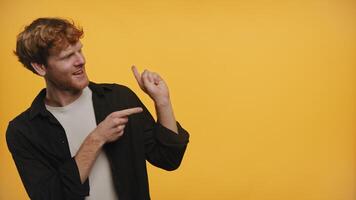 Man smiling and pointing sideways on a yellow background video