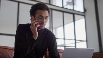 Man Talking on Smartphone While Using Laptop video
