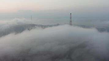 Drone view of the city, bay and big bridge covered with fog at sunset video