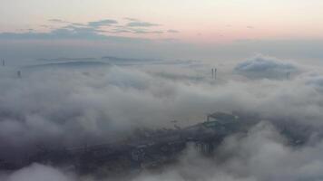 Drone view of the city, bay and big bridge covered with fog at sunset video