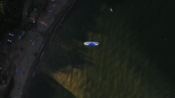 Aerial view of a paraglider with an engine flying by the coast of the sea video