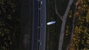 Engine-powered paraglider over highway. Top-down aerial view video
