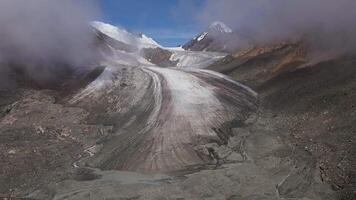 Aerial view of glacier tongue in cracks in mountains video