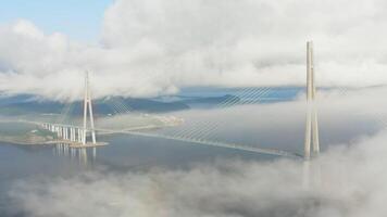 Aerial view of the Russian bridge surrounded by fog at dawn video
