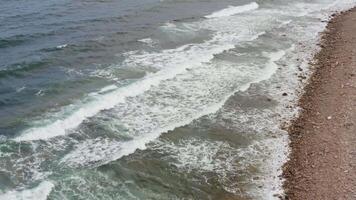A view of the ocean and waves crashing against the rocky shore with white foam video