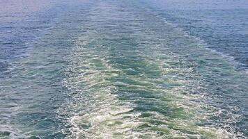 Waves and ripples on the water surface from a moving boat, creating a scenic trail. video