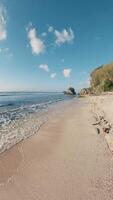 Walking on ocean beach on sunny day in Bali. Vertical footage, first person view video