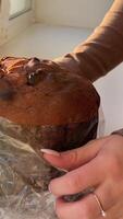 Filmed with vertical movement on the panettone. stands out on the table, an Italian specialty of pastry. The Christmas decorations embellish the table, you can glimpse a glass ready to toast. video