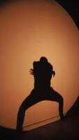 Silhouette of a performer in dynamic pose video
