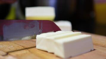 Chef in black gloves cuts butter to add to salad video