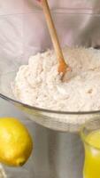 Close-up of a young woman mixing butter with flour in a bowl on the kitchen table, preparing a grated pie according to the recipe. Concept of homemade baking, preparing ingredients video