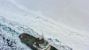 Top view of a tug making its way through the ice at sunset video