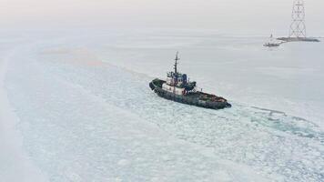 Tug making its way through the ice against the backdrop of the lighthouse video