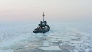 View of a tug making its way through the ice at sunset video