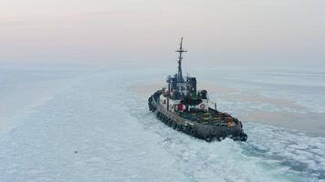 Drone view of the tug from the stern, making its way through the ice at sunset video