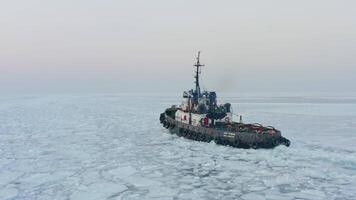 Tug making its way through the ice against the backdrop of the lighthouse video