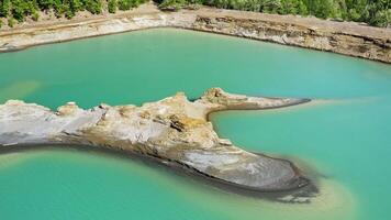 Drone view of the turquoise lake formed as a result of mining waste video