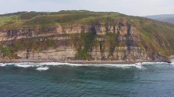 Aerial view of the picturesque high coastline, sharp cliffs and raging sea video