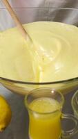Bakery. Closeup view of a woman beating a key lime pie cream in a glass bowl with an electric mixer. video